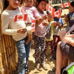Guatemalan children holding hand held Canadian flags