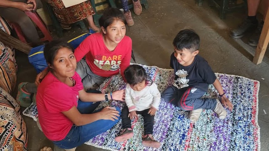 A happy young family sitting together on the floor